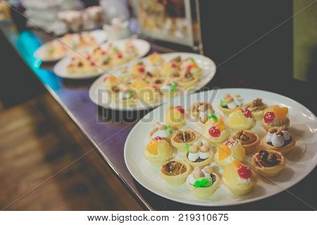Bacon Shrimp, fried calamari and antipasto appetizer sitting on table with white table cloth in fine dining restaurant with window light. Film grain look