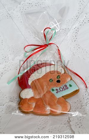 Christmas sweets in a festive package, colorful gingerbread, cookie in the form of a dog with New Year's mood. Year of the dog. Dog symbol of the year 2018. Close-up. Colorful christmas Gingerbread