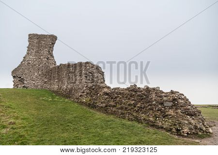 Derelict wall at old castle rising uphill