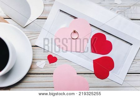 Proposal of marriage. Ring and confess in love. A cup of coffee on the table and a ring as a gift. Marriage propose.
