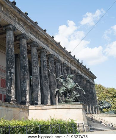 BERLIN GERMANY - AUGUST 28 2017; Exterior colonnade of historic Altes Museum on Museum Island in middle of city with statues of Lion Fighter on horseback by Albert Wolff guarding the entrance steps.