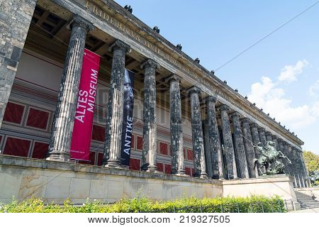 BERLIN GERMANY - AUGUST 28 2017; Exterior colonnade of historic Altes Museum on Museum Island in middle of city with statues of Lion Fighter on horseback by Albert Wolff guarding the entrance steps.
