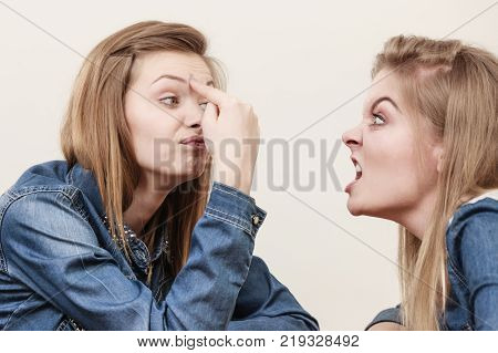 Two women having argue mocking up being mad at each other. Female telling off ignorance coversation concept.