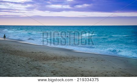 Sunset At The Beach With Tourists Enjoying