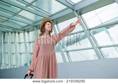 Young woman in international airport walking with her luggage.