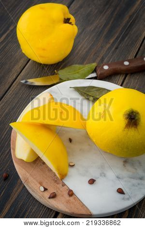 Sliced yellow quince or queen apple autumn fruits with seeds on marble cutting board