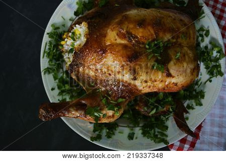 roast in the oven chicken with garnish on a platter with greens