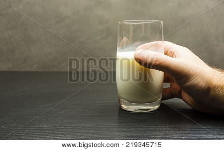 A glass of fresh milk raised from the table.