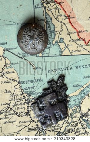 ILLUSTRATIVE EDITORIAL.Polish Army insignia (found with metal detector near Kiev).German vintage map of Central Europe circa 1944 fragment.Poland under occupation.
Kiev,Ukraine December 22 ,2017