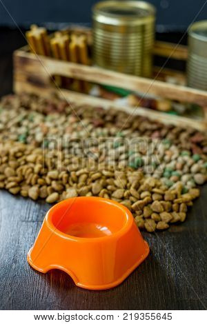 Small orange bowl for pet food and dry food as background