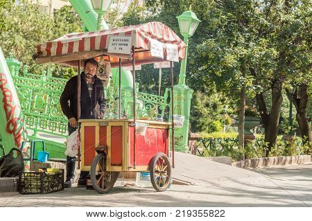 Eskisehir Turkey - June 14 2017: Man selling fresh boiled and roasted corn near the brigde on Porsuk River Eskisehir on a sunny summer day. Corn is famous summer street food in Turkey.