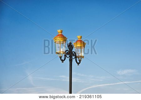 Lamppost against blue sky with light clouds