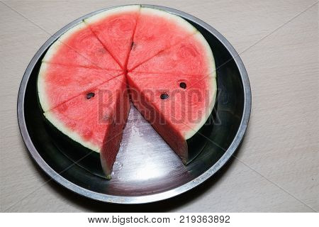 Some sliced watermelon on the steel tray.