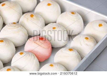 Dessert Chinese pastry or mooncake for Chinese new year in baking tray on table background. Baking ingredients for homemade making the dough with salted egg yolk and a scented candle.