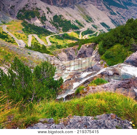 Small waterfall on the top of famous Italian Stelvio High Alpine Road elevation of 2757 m above sea level. Stelvio Pass South Tyrol province of Sondrio Ortler Alps Italy Europe.