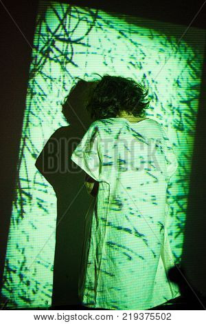 Young woman with straitjacket standing back on ligth background