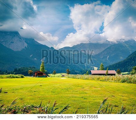 Green meadow on the Golf club Zugspitze Lermoos village loccation. Colorful summer morning in Austrian Alps Reutte district state of Tyrol Austria Europe. Artistic style post processed photo.