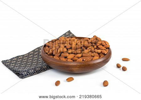 Almond in a wooden bowl with classic cloth on a white background. clipping path