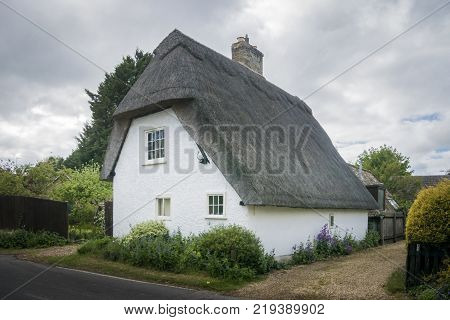 Street view of an old thatched cottage in the pretty village of Foxton Cambridgeshire England UK