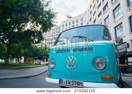 BERLIN GERMANY - AUGUST 28 2017; Blue VW Kombi van front with renown emblem parked in Berlin street.