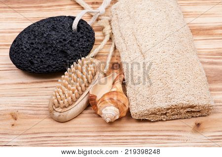 Natural bristle hand and nail wooden brush, volcanic pumice stone, loofah sponge and shell on wooden vintage background