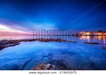 Coastal city on sunset, view on Batroun and mediterranean sea, glowing lights from the houses at night, Batroun is a coastal city in northern Lebanon and one of the oldest cities in the world