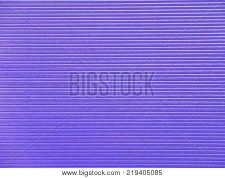 Dark violet horizontal corrugated paper texture closeup.