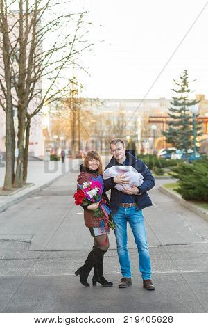 Happy Father Meets His Wife With A Newborn Baby
