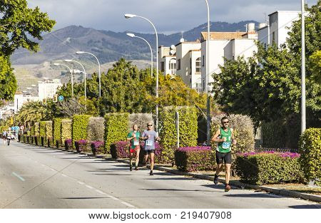MALAGA SPAIN - DECEMBER 10 2017: Athletes run during Zurich Maraton Malaga on the streets of Malaga city Andalusia Spain. More than 3400 marathoners took part in the 8th Malaga Marathon