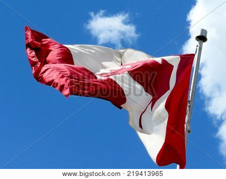 Canadian flag waving in the blue sky above the city Thornhill Canada May 17 2016