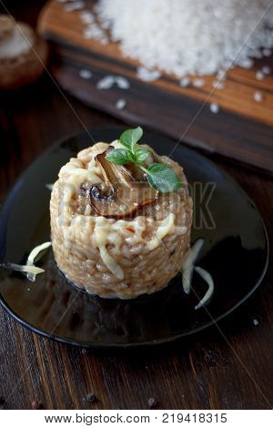 Italian mushroom risotto on black ceramic plate over table