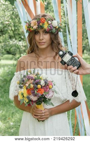 Photographer measuring light with light meter on beautiful girl.