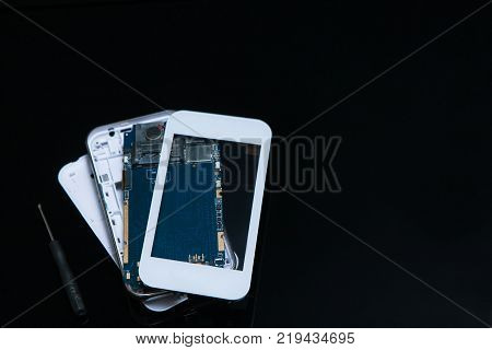 mending workshop smartphone black background. engineering craftsmanship. professional repairs of mobile devices and other gadgets