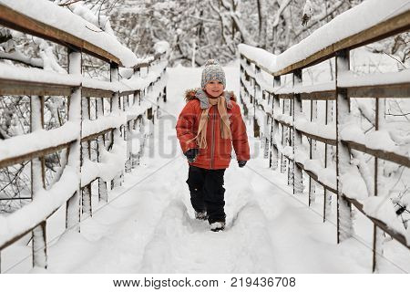 Little Cheerful Boy Runs In Winter On Bridge.