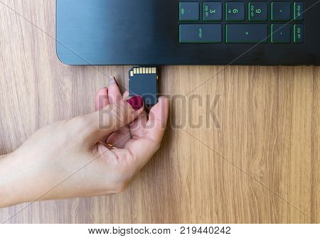 Hands Show Memory Card of Laptops user on working table desk