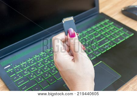 Hands Show Memory Card of Laptops user on working table desk