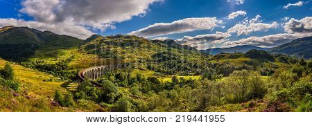 Summer panorama of Glenfinnan Railway Viaduct in Scotland and surrounding mountains