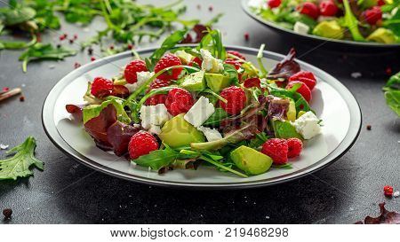 Fresh Tasty Raspberry salad with avocado, green vegetables, nuts, feta cheese, olive oil and herbs. healthy food