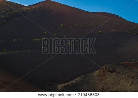 timanfaya national park, Lanzarote, Canary islands, Spain. Red mountains in the distance. Clear blue sky. Red Mountains in focus. Landscape.
