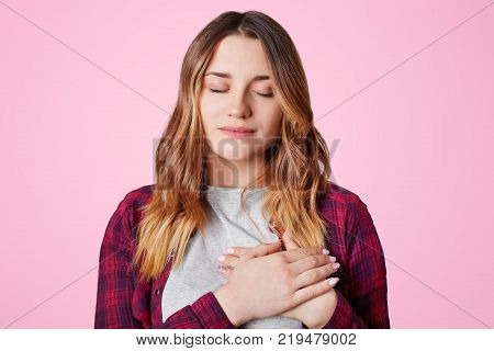 Headshot Of Unhappy Sorrorful Female Curves Lips, Looks Desperately At Camera, Being Upset To Hear B