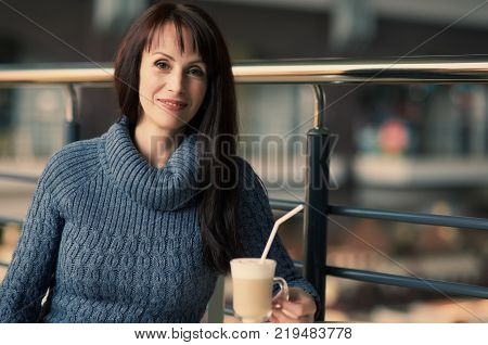 happy lonely woman drinking coffee in cafe