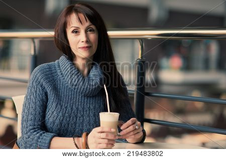 happy lonely woman drinking coffee in cafe