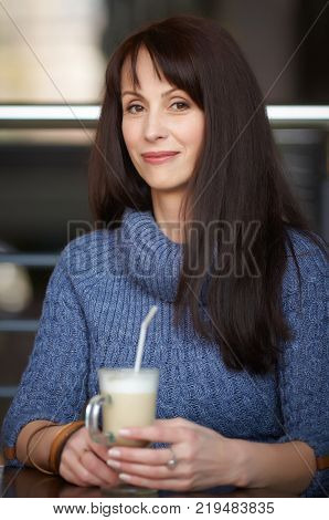 happy lonely woman drinking coffee in cafe