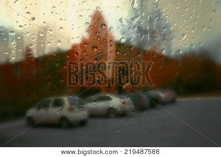 Autumn street on a rainy day view through wet glass