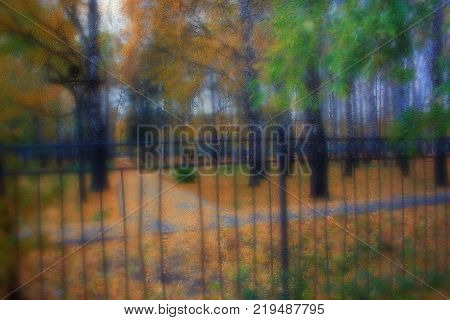 Autumn street on a rainy day view through wet glass