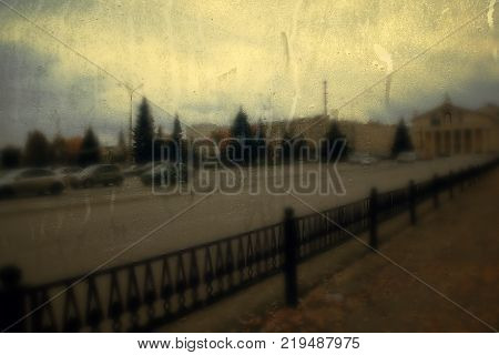 Autumn street on a rainy day view through wet glass