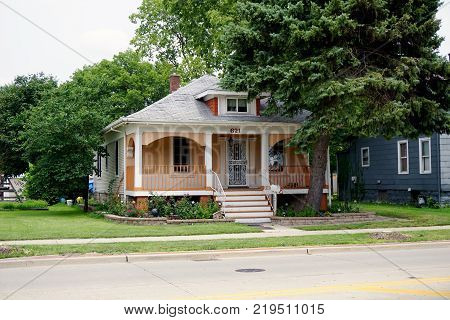 JOLIET, ILLINOIS / UNITED STATES - JULY 26, 2017: A small, single family, Cape Code style home, with a front porch, on Plainfield Road in Joliet.