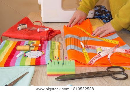 Female fashion designer working at studio with pattern cuttings and sketches. Garment industry tailoring concept
