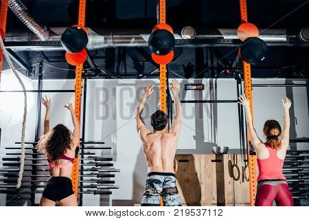 fitness, sport and exercising concept - group of people with medicine balls training in gym