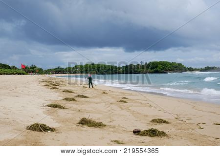 Nuca Dua, Bali, Indonesia - DECEMBER 21, 2017: Cleaning the beach from algae and garbage during the rainy season